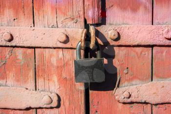 Old iron lock on weathered door painted in red color in Astrakhan, Russia