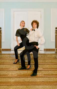 Couple posing on stairs of fancy hall toned image