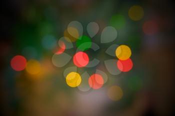 Blurred background of defocused christmas lights on christmas tree full of green mist.