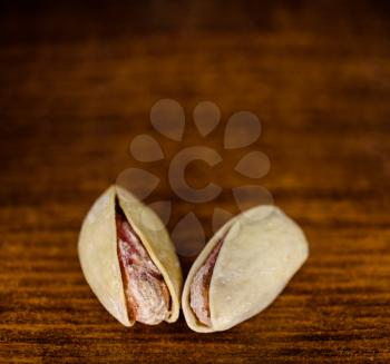 Two Pistachio nut on a wooden board macro image with a lot of copyspace on top