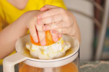 Royalty Free Photo of a Child Using a Juicer