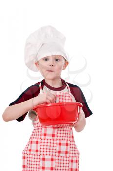  boy in chef's hat makes the dough in a bowl isolated on white background