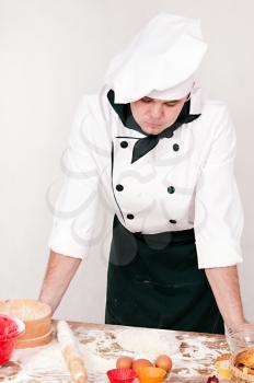 pensive chef is thinking on the gray background