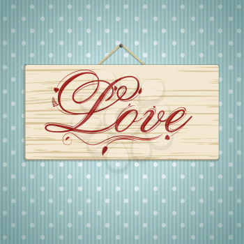 Wooden sign with 'love' in scripted decorative text on a blue background with polka dots