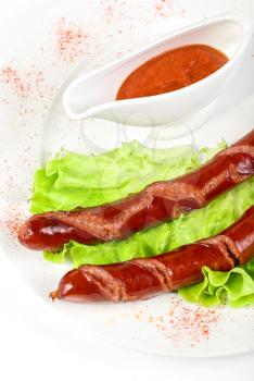 Royalty Free Photo of Grilled Sausage on Lettuce