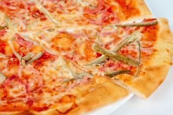 pizza closeup with boiled sausage, ham, marinated gherkin and mozzarella cheese