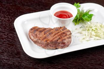 Juicy roasted beef steak with vegetables closeup at plate