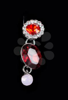 Beautiful earring with colorful red gems on black background