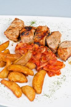 Grilled kebab pork meat with roasted potato and vegetables