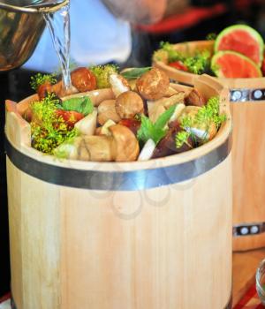 preserved mushrooms with vegetables in wooden jar
