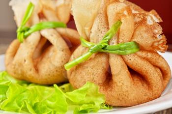 tasty pancakes stuffed with meat served with lettuce and green onion