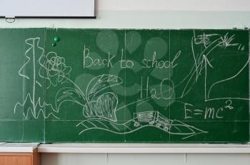 Green chalk blackboard written Back To School with white chalk