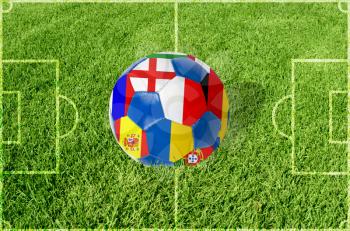 Soccer ball on grass field background. Ball filled with euro 2012 countries flags colors.