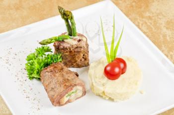 Grilled meat rolls from beef meat with mozzarella, ham, asparagus and mashed potatoes