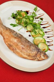 Fried peled fish with cucumbers and greens
