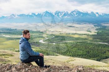 Man watching to glacier in Altai mountains. Resting in mountains or global warming concept