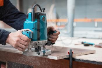 Furniture production or craft concept: worker polishing the wood surface of furniture part with polish machine