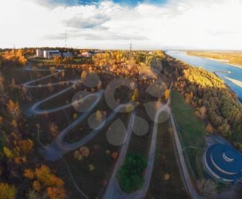 Aerial top vew of winding road in the city, drone shot. Barnaul, Siberia, Russia. Beauty autumn day