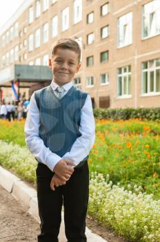 The first time in first class: happy schoolboy at school background