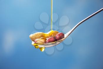 Natural peanut oil with spoon and nuts