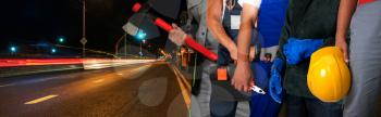 Workers on a road construction, repairing the road in the night city