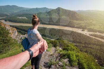 Follow me concept - Woman wanting her boyfriend to follow her in travel on the top of mountain in Altai