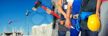 Many workers closeup with equipment on building background