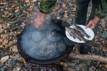 delicious fresh-soup from fish cooked in the metal pot at outdoors
