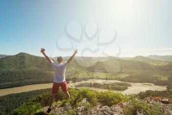 Man standing on top of cliff in summer beauty day in Altai mountains