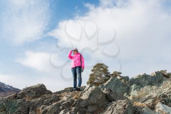Happy woman relaxing on the top of mountain at beauty sunny spring day, in Altai mountains. Travel vacation concept.