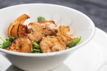 Fried shrimps with yogurt sauce and greens on plate