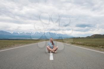 Woman sitting on the beauty road in mountain