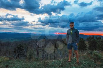 Travel, freedom and tourism concept - man standing on top of cliff in summer beauty evening in Altai mountains