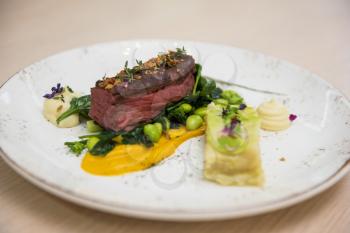 Beef meat with green peas, sweet potato mousse, roasted spinach and zucchini gratin