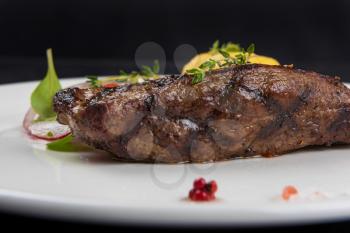 Grilled beef meat with potato and vegetables on white plate