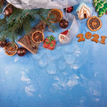 Ney year 2021 holiday blue concrete background with fir branches, toys garland and decorations. Xmas and Happy New Year theme. Flat lay, top view, space for text