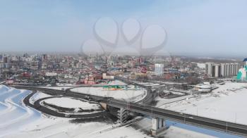 Aerial shot of bridge and car driving on the bridge, winter sunny day in Barnaul, Siberia, Russia