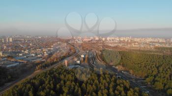 Aerial view of autumn siberian forest and city