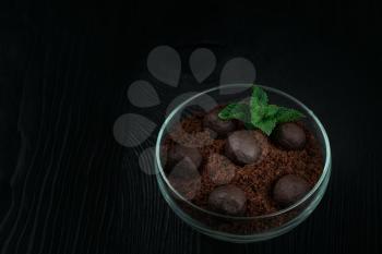 Chocolate dessert of cookies with pieces of chocolate and mint on a dark wooden background with copyspace, food and drink concept