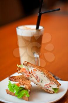 Sandwich with cheese and salmon and vegetables with latte