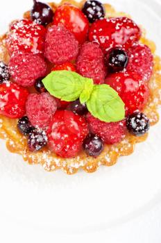 Cake with fresh berries and mint closeup