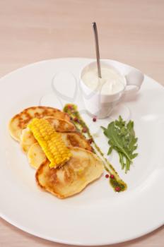 corn pancakes with cream at plate
