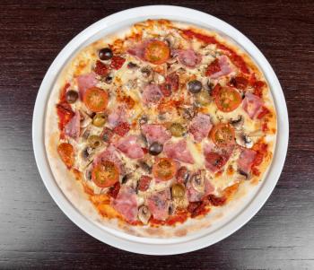 pizza with ham and mushrooms at the table