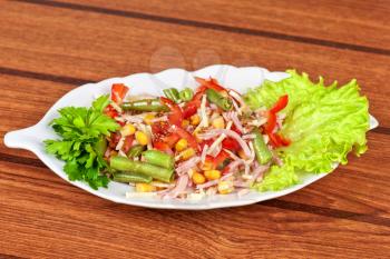 Salad from ham, tomato, green beans, corn and greens