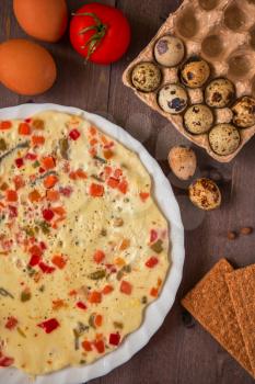 baked omelette with different eggs and vegetables with rye small load of bread