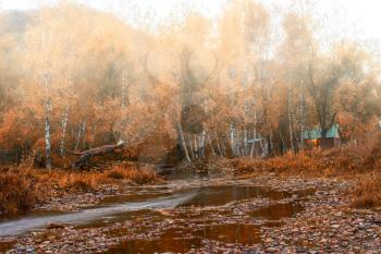 Autumn at mountain village. Morning fog at river