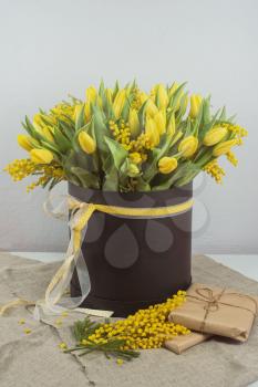 Bright spring bouquet of tulips and mimosa flowers. Mother's Day or Easter theme.