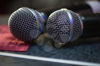 Closeup of audio microphones on stage background