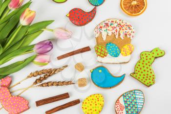 Tulips and gingerbread cookies on white background for Easter.