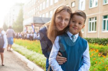 The first time in first class: happy schoolboy with his mother going to the school in first time